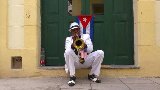 一位爵士音乐家在古巴哈瓦那的街道上吹小号视频素材模板下载