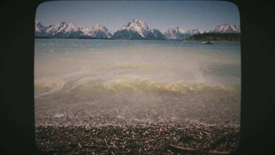 波浪滚滚到雪山附近的湖岸上8毫米电影风格