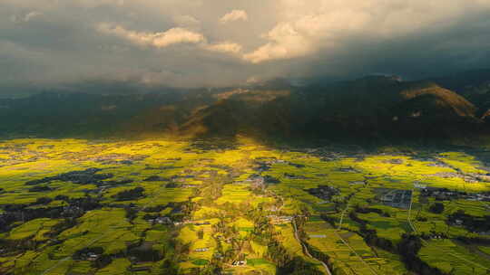 夕阳日落 高山下的乡村金黄油菜花田视频素材模板下载