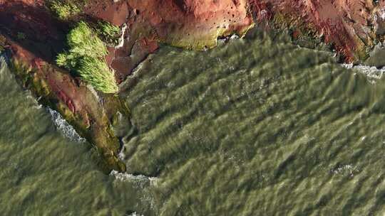 俯拍海岸边海浪拍打礁石