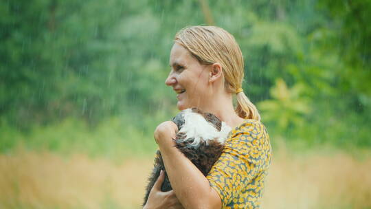 抱着小狗淋雨的女人