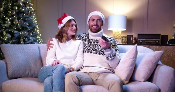 圣诞节夫妻坐在沙发上看电视