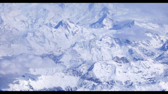 航拍飞机在雪山上空飞行