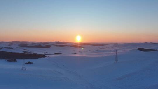 冬天丘陵地带雪域夕阳输电线路