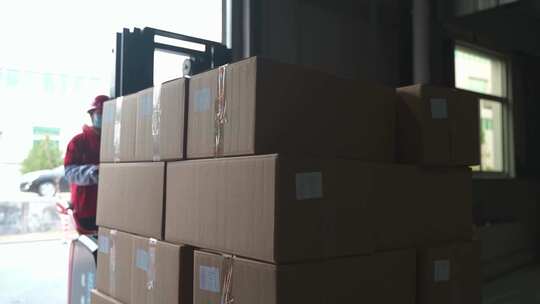 仓库工人操作叉车搬运纸箱