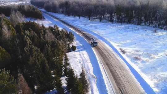 冬天，吊杆升降机卡车行驶在风景如画的森林中