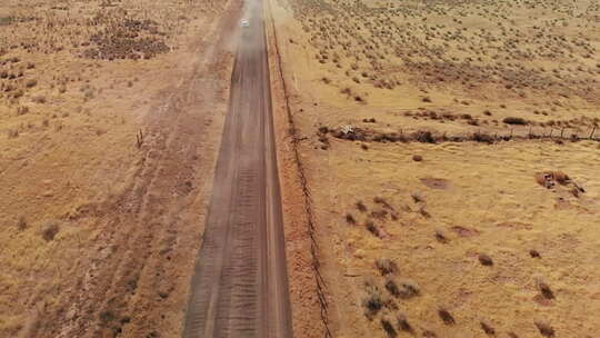 沙尘暴导致开阔沙漠公路上的旅行车，空中视频素材模板下载