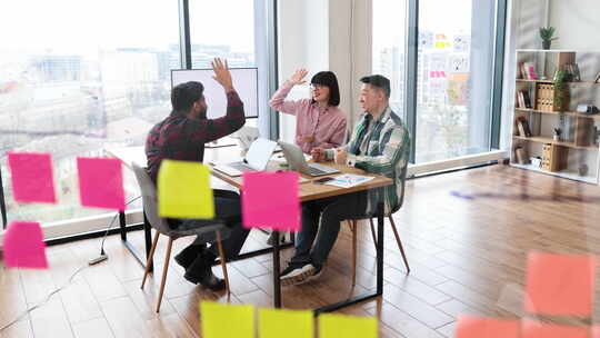 快乐的建筑师团队在办公室会议中庆祝成功