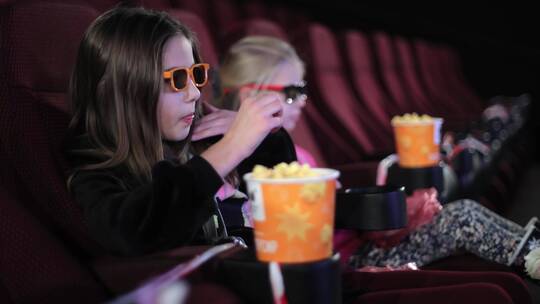 两个女孩在电影院看电影视频素材模板下载