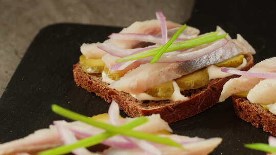 木桌特写荷兰斯堪的纳维亚三明治配鲱鱼洋葱
