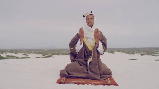 男人在穆斯林沙漠祈祷