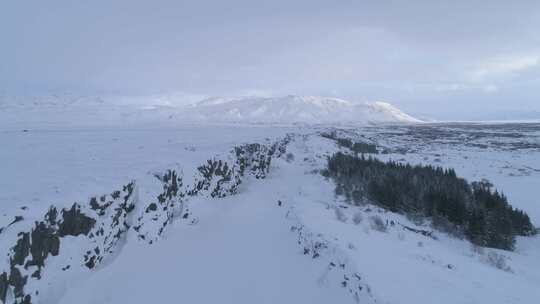 人们在山脊天线附近的雪中行走