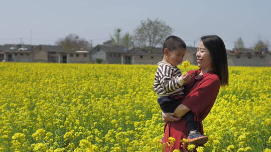 中国女性和小朋友在油菜花田地中玩耍