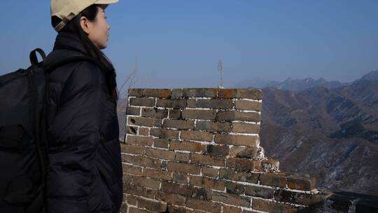 中国女性站在长城顶端拍摄风景