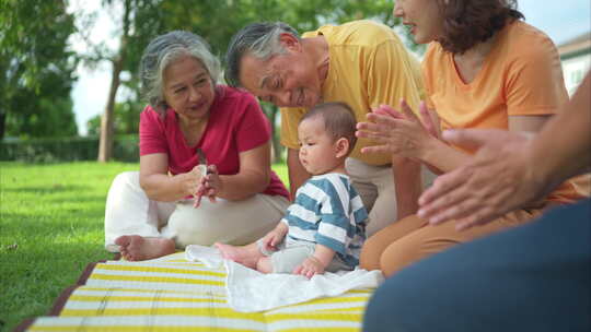 祖父母和带着小孩的父母正在公园里玩得开心