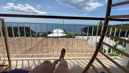 在阳台的摇椅上欣赏海景