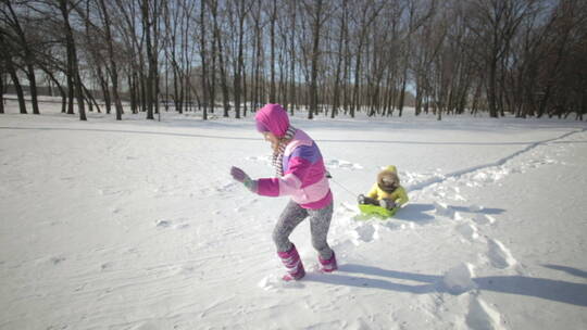 玩雪橇的妈妈和孩子