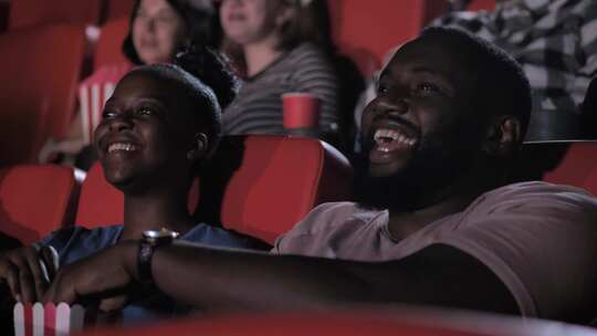 非洲裔美国夫妇在电影院欣赏喜剧