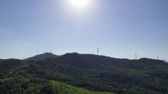 阳光下电塔航拍山上电网森林山区电线电力塔