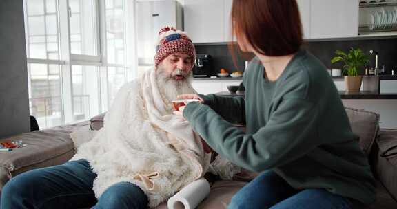 一个穿着绿色夹克的黑发女孩给她生病的老年