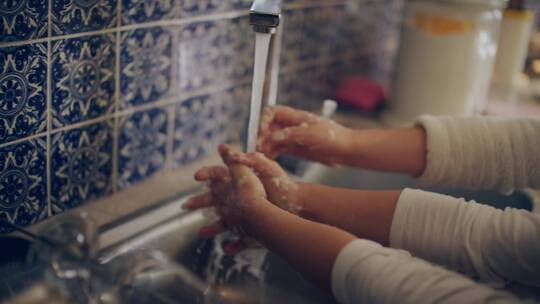 两姐妹在水龙头下洗手的特写镜头   
