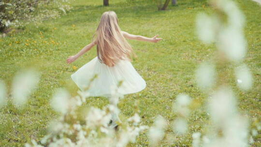 白色连衣裙女孩在草地旋转
