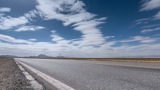 戈壁荒漠公路在逆光蓝天下的延时