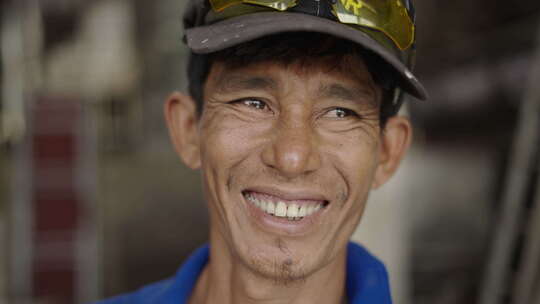 亚洲成年男子工人在工作区对着镜头微笑