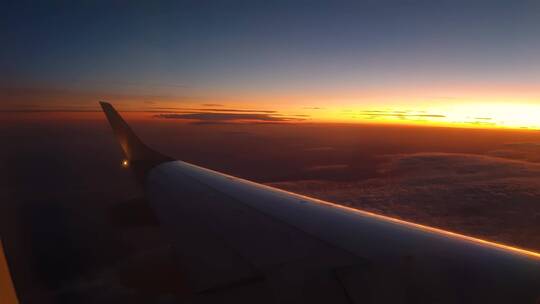 飞机一侧机翼在夕阳下的风景