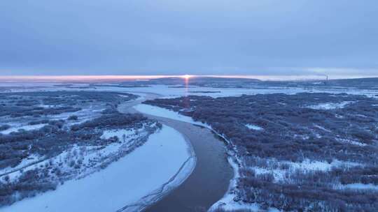 航拍晨曦中的雪原河流景观