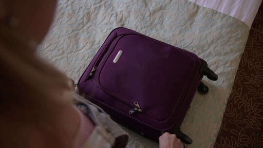 女子打开紫色手提箱视频素材模板下载