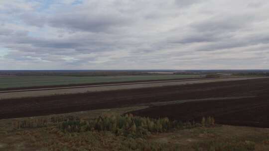 乌拉尔秋季蓝天下绿色和棕色的乡村田野