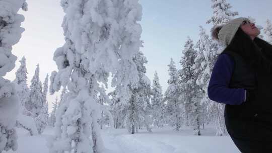 芬兰北极圈拉普兰雪林中探索美丽风景的女孩视频素材模板下载