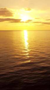 日落时的海面垂直航拍相机飞越平静的金海太