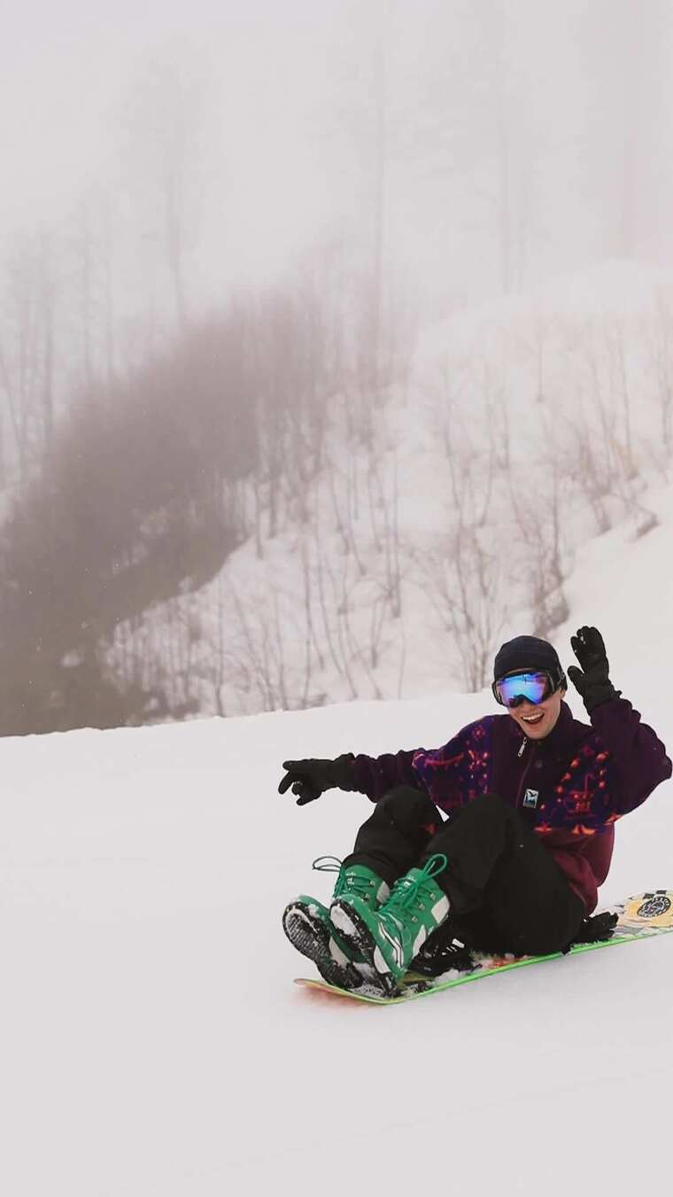男人坐在单板滑雪上