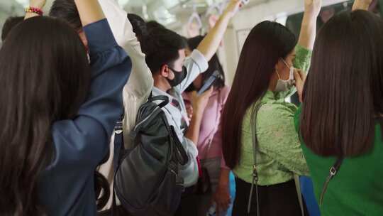 拥挤的公共地铁列车上一群戴口罩的人