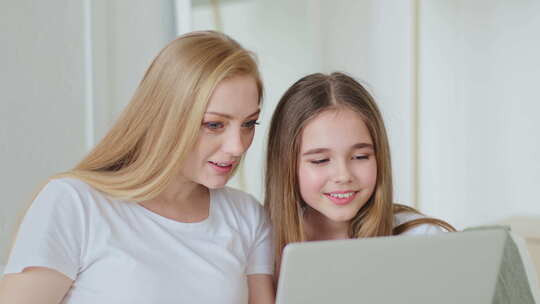 中年母亲和女孩在家里看电脑