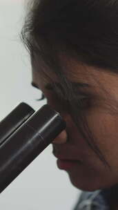 女人通过显微镜观察新型细菌