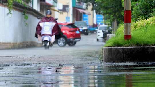 雨中正面驶来的骑电瓶车女人