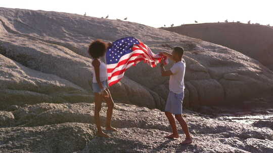 阳光海滩上举着美国国旗的夫妇视频素材模板下载