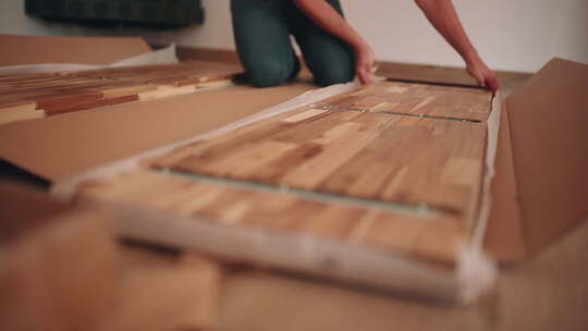 拆箱后测量一块木板用于DIY桌子组装。特写