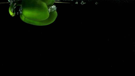 绿色甜椒落在水下，用高速摄像机以1000