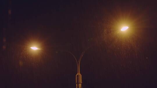 昏黄路灯映照下的瓢泼大雨