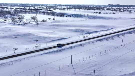 雪后旷野中行驶着一辆车的景象