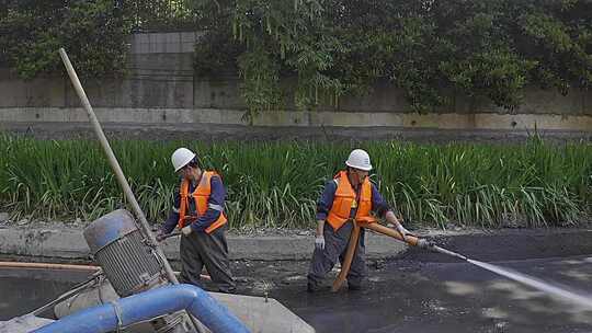 工人操控设备清理河道淤泥