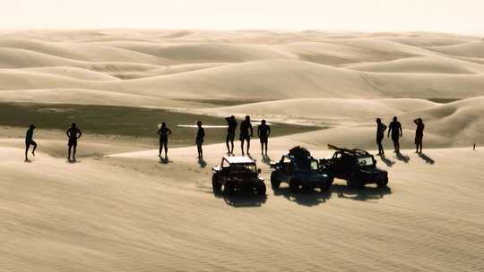 高高的沙丘上剪影的人，马车旅行中有风的条件；空中