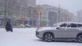 4k北方城市下大雪的马路推着电动车的行人高清在线视频素材下载