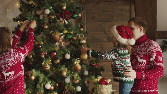快乐的家庭在家里装饰圣诞树视频素材模板下载