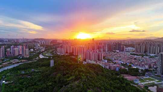 惠州大亚湾夕阳下的城市高楼与山林景观