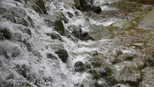 水流冲击布满青苔岩石的自然景观